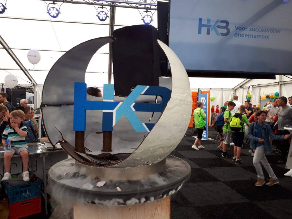 Tentoonstelling met HK3 logo en publiek.