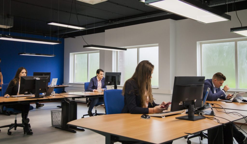 Mensen werken in een modern kantoor met computers.