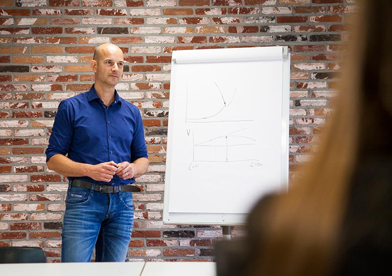 Man geeft presentatie bij flipover met grafieken