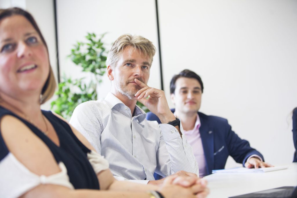 Zakelijk overleg met meerdere mensen aan tafel.