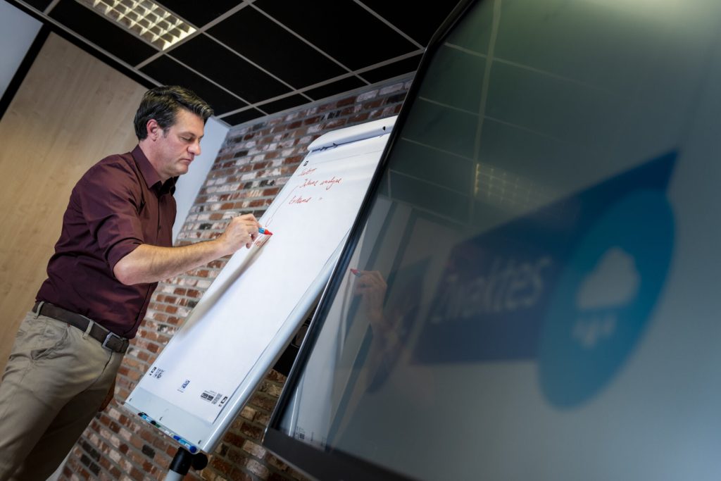 Man schrijft op whiteboard in vergaderruimte.