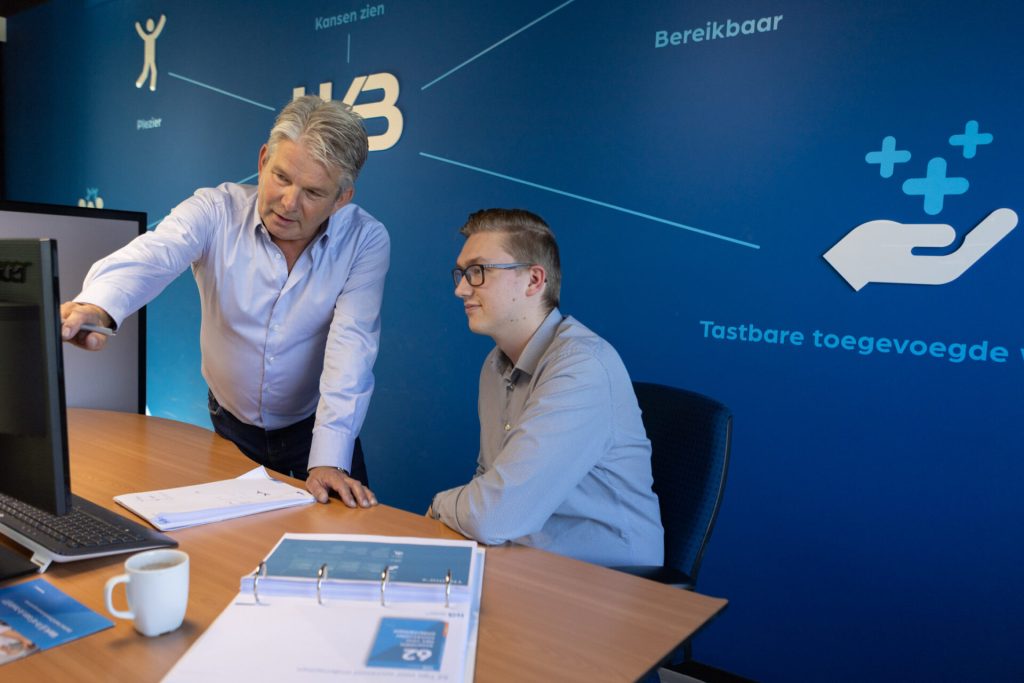 Twee mannen analyseren gegevens op computerscherm.