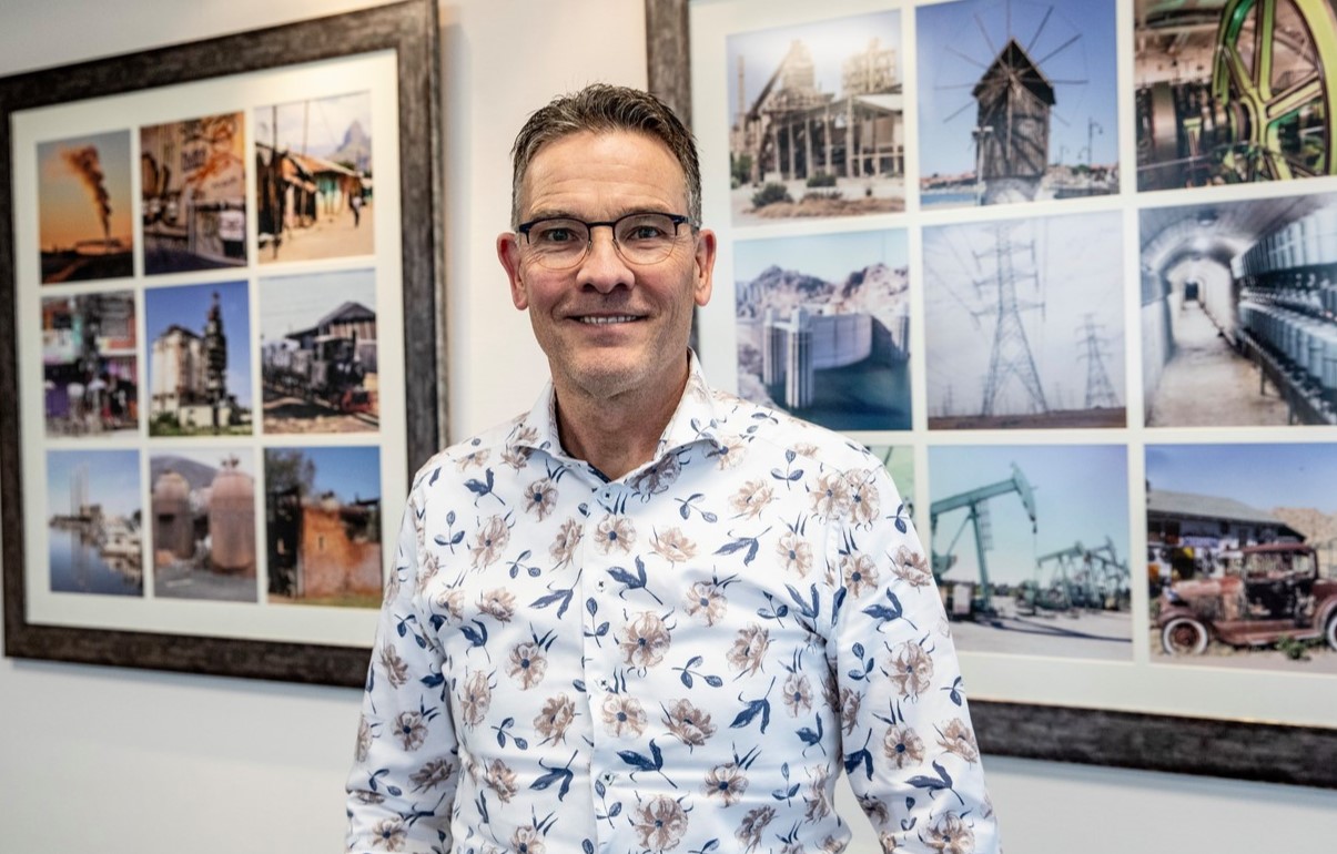 Man bij fotowand in kantoor.