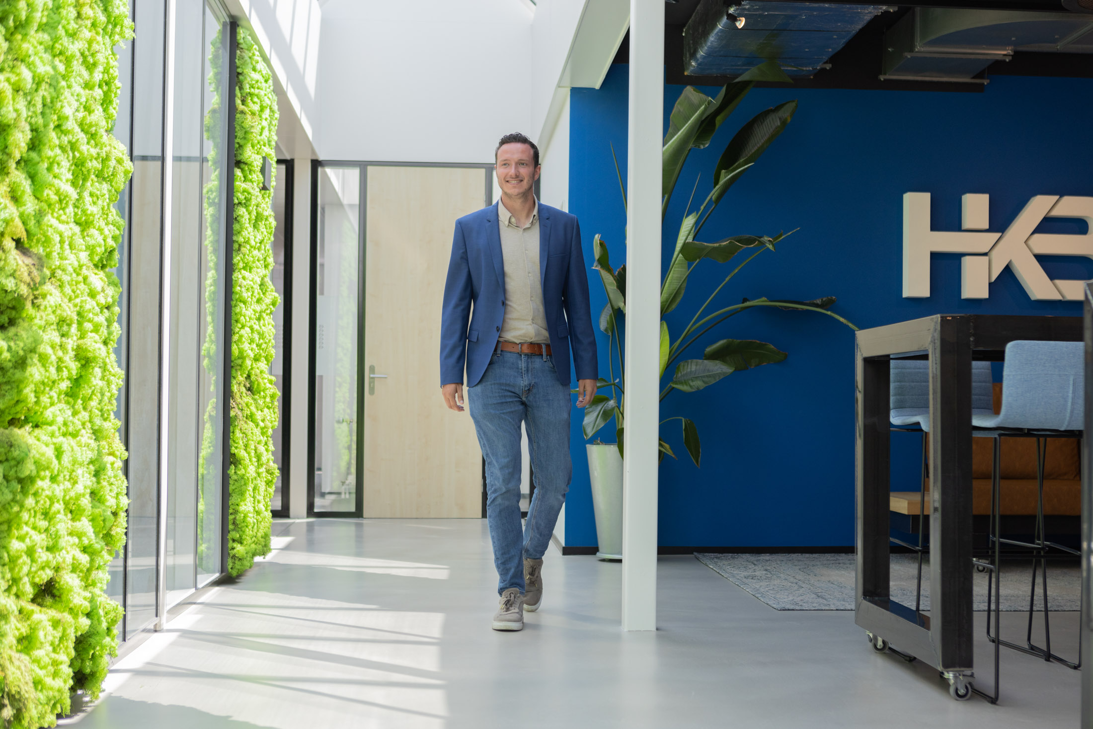 Man loopt in modern kantoor met groene muur