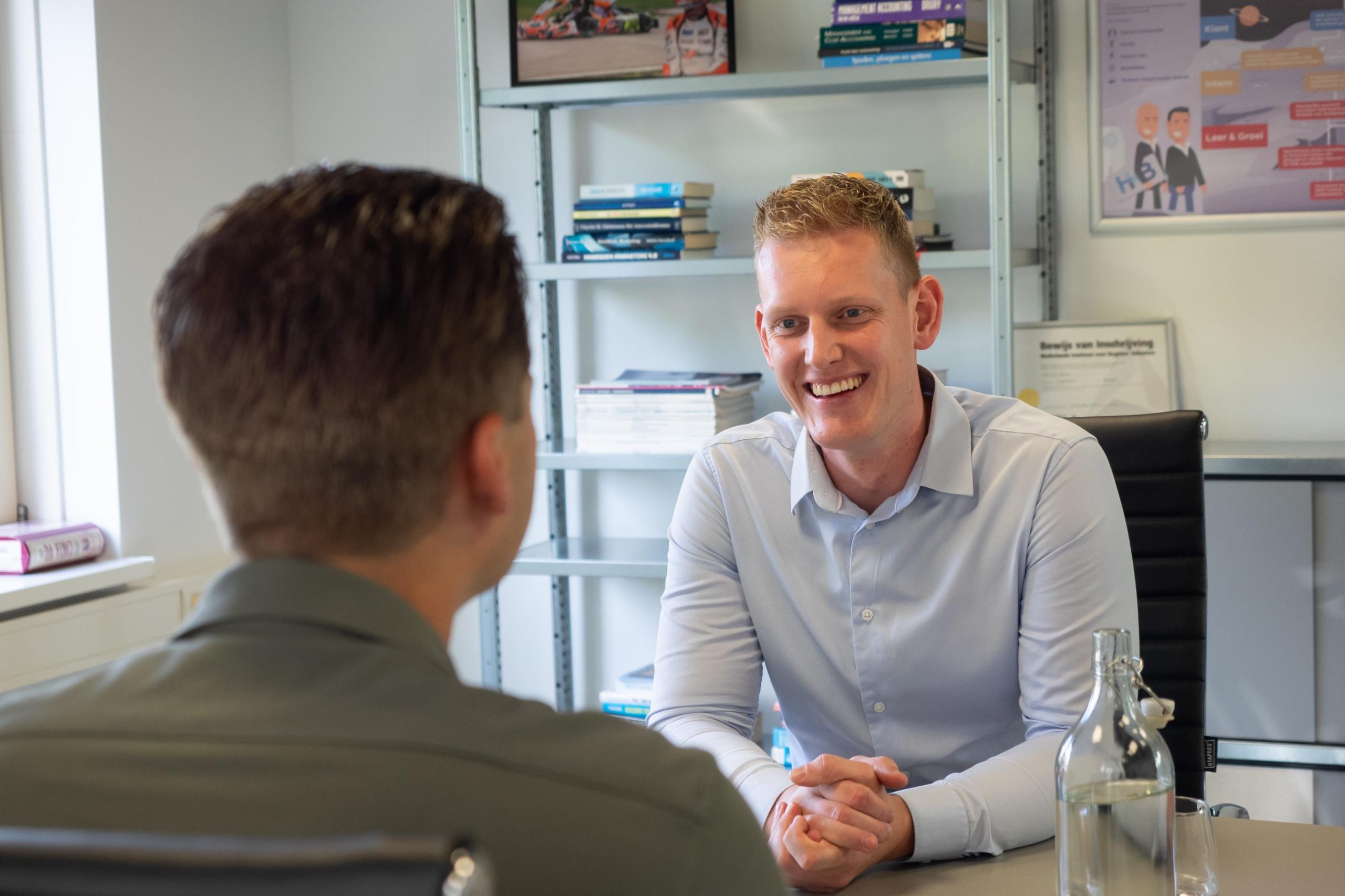 Twee mannen in gesprek op kantoor.