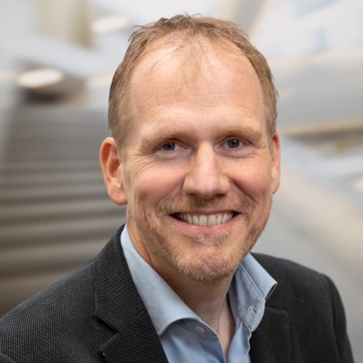 Lachende man met baard in zakelijke omgeving.