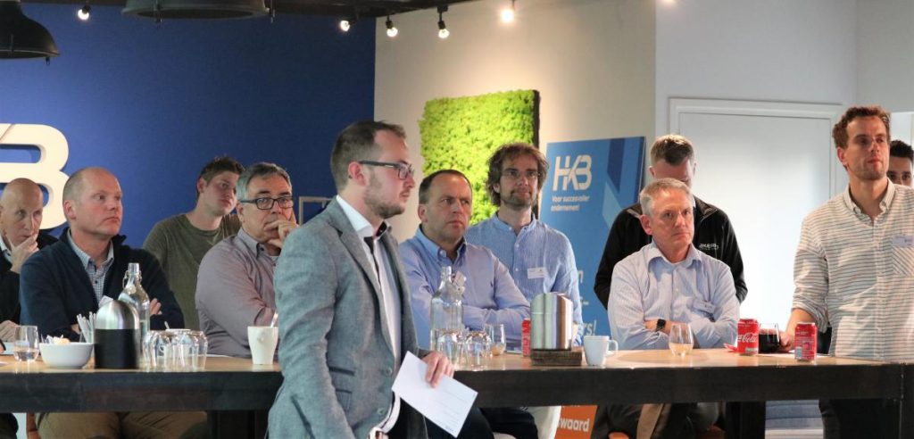 Mensen luisteren naar een presentatie tijdens een bijeenkomst.