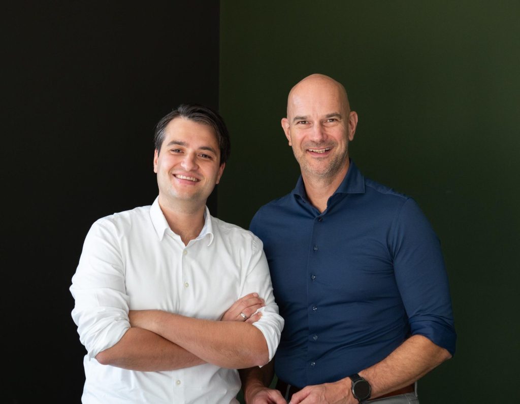 Twee lachende mannen in zakelijke kleding.