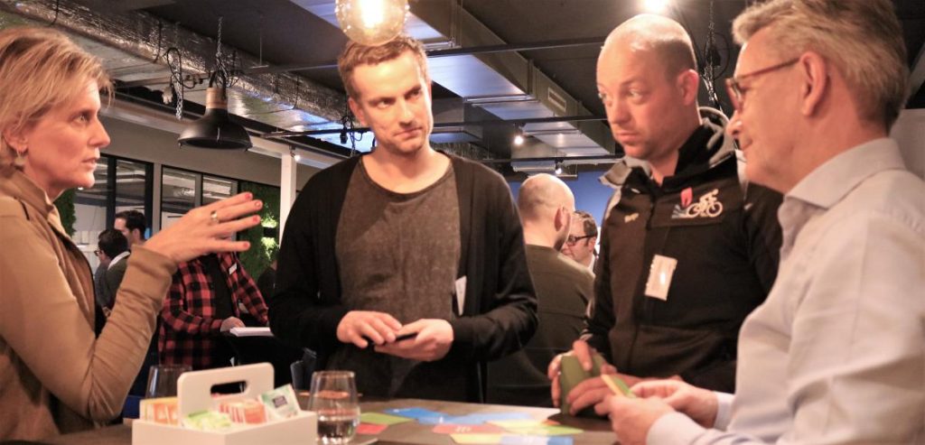 Groepsdiscussie bij een tafel in een moderne ruimte.