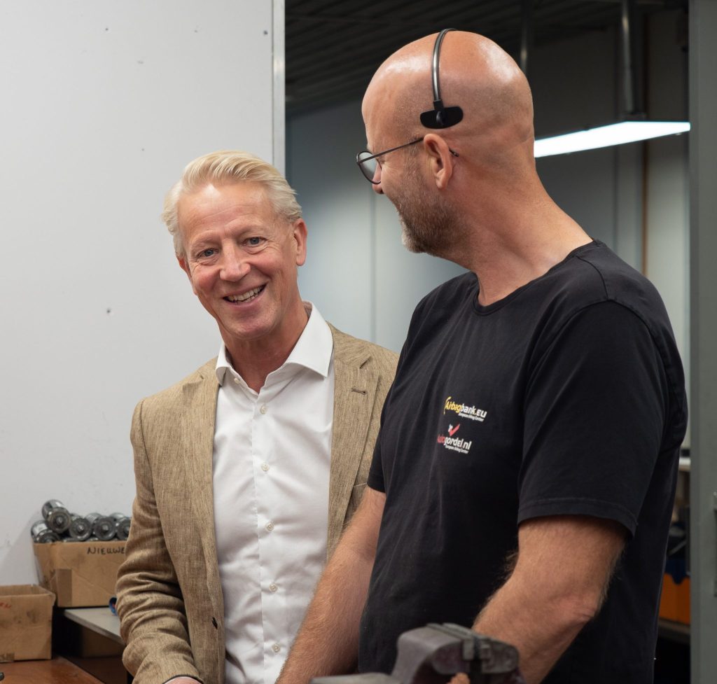 Twee mannen praten in werkplaats.