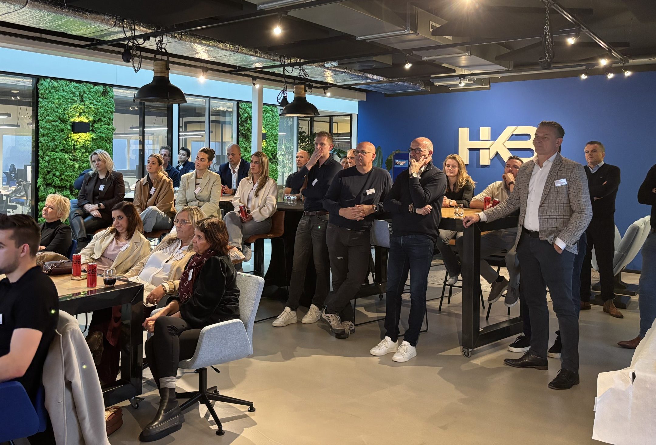 Groep mensen luistert naar een presentatie in kantoor
